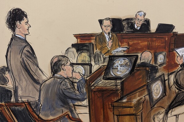 In this courtroom sketch, Sam Bankman-Fried, far left, standing as the jury foreman, standing far right, reads the verdict with Judge Lewis Kaplan presiding over the federal court bench of Manhattan, Thursday, November 2, 2023, in New York.  A New York jury has convicted FTX founder Sam Bankman-Fried on fraud charges.  The 31-year-old Californian was convicted Thursday in a Manhattan federal court by jurors who rejected his testimony that he did not defraud clients.  (Elizabeth Williams via AP)