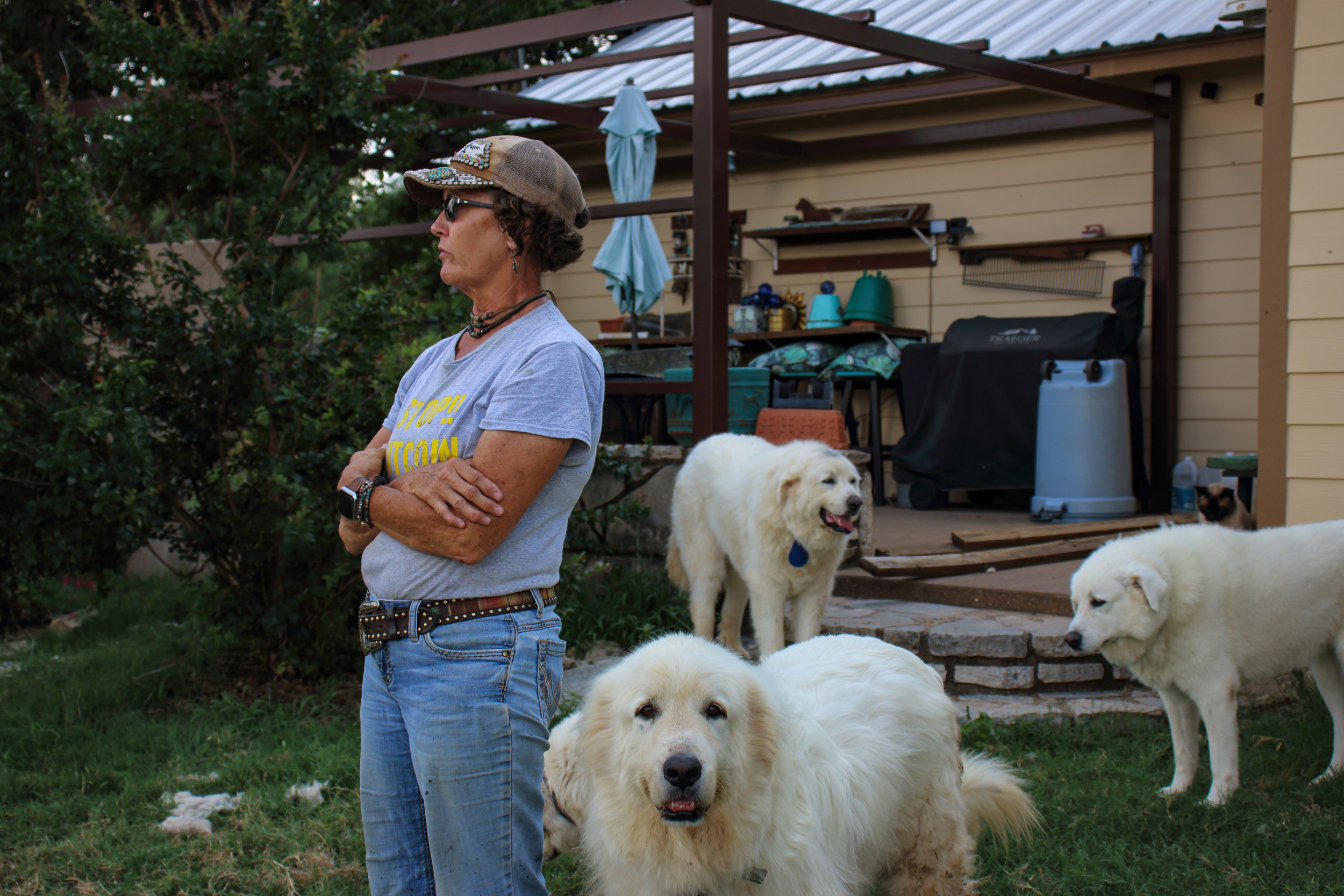 Cheryl Shadden stands in her backyard with several of her Great Pyrenees dogs. Credit: Keaton Peters/Inside Climate News